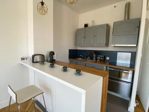 une cuisine blanche avec un comptoir et un évier dans l'établissement Superbe Vue sur le Vieux Port 70 m2 avec une Terrasse & Parking, à Marseille