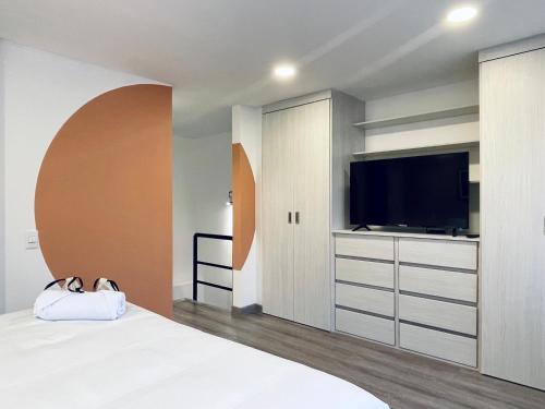 a bedroom with a bed with a tv and a cabinet at Palace by Wynwood House in Bogotá