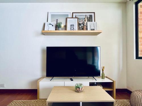 a living room with a tv and a coffee table at Palace by Wynwood House in Bogotá