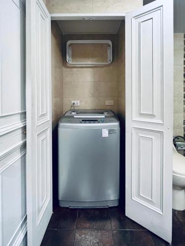 a washer and dryer in a small kitchen with white doors at Palace by Wynwood House in Bogotá