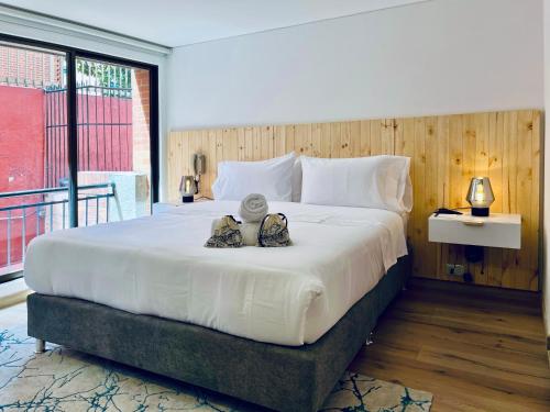 a large white bed with two stuffed animals on it at Palace by Wynwood House in Bogotá