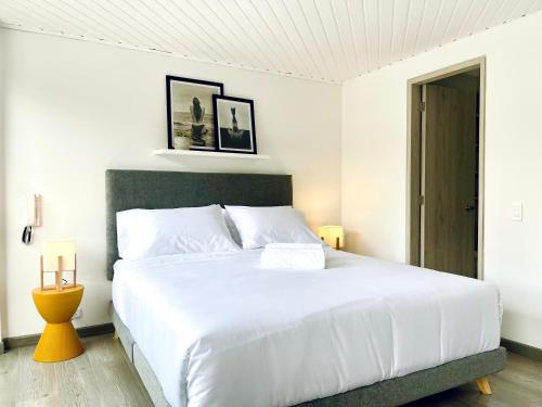 a bedroom with a large white bed with white pillows at Palace by Wynwood House in Bogotá
