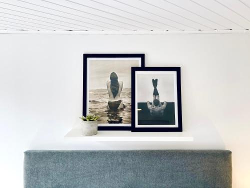 two framed photographs on a white wall in a living room at Palace by Wynwood House in Bogotá