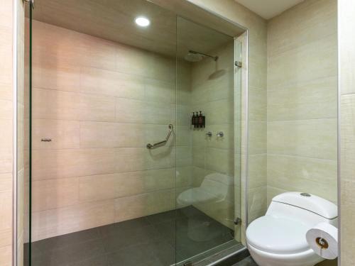 a bathroom with a toilet and a glass shower at Palace by Wynwood House in Bogotá