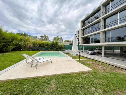 a pool with a bench next to a building at Apartamento Dock Trade Fisherton in Rosario