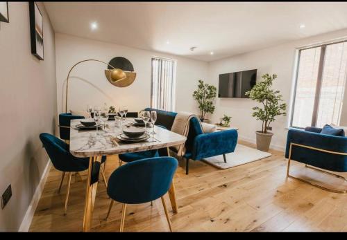 Atlantic Suite - Wyndale Living - BHam JQ Lux 2 BR في برمنغهام: غرفة طعام مع طاولة وكراسي زرقاء
