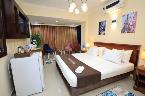 Pokój hotelowy z dużym łóżkiem i biurkiem w obiekcie Cairo City Center Dreamers Hotel & Suites w Kairze