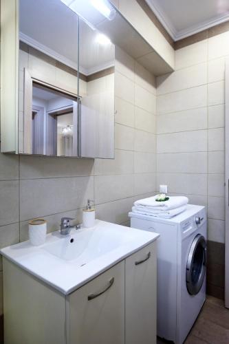 a bathroom with a washing machine and a sink at Neapolis Apartment in Lefkada