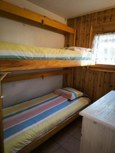 deux lits superposés dans une chambre avec fenêtre dans l'établissement Appartement à 50m des remontées, à Saint-Gervais-les-Bains