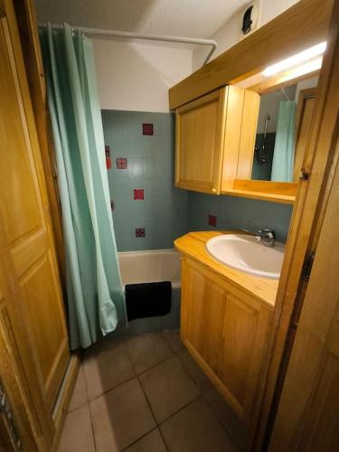 une salle de bain avec un lavabo et un rideau de douche dans l'établissement Appartement à 50m des remontées, à Saint-Gervais-les-Bains
