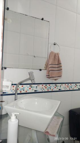a bathroom with a sink and a mirror at Pousada Tia Rosi com suites independente 100 mts da praia c ar, energia solar e atendimento vip in Rio das Ostras