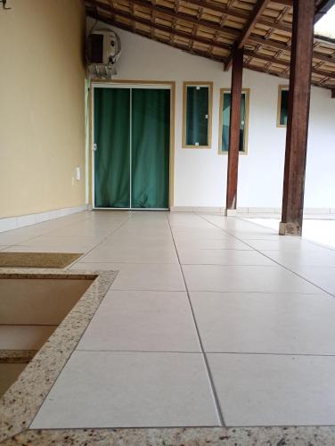 a large empty room with a green door at Pousada Tia Rosi com suites independente 100 mts da praia c ar, energia solar e atendimento vip in Rio das Ostras