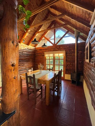 comedor con mesa de madera y sillas en Cabañas Temistocles en Esquel