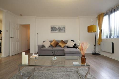 a living room with a couch and a glass table at Spacious Apartment - Long stays welcome in Luton