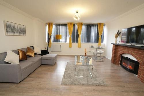 a living room with a couch and a fireplace at Spacious Apartment - Long stays welcome in Luton