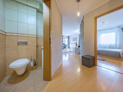 a bathroom with a toilet and a room with a bed at CITYSTAY Reja Apartament z parkingiem in Gdynia