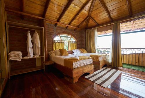 a bedroom with a bed and a large window at Casa de Vista Alta in Mindo