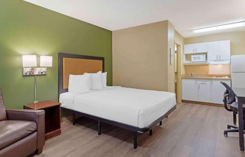 a bedroom with a bed and a couch and a kitchen at Extended Stay America Select Suites - Durham - University in Durham