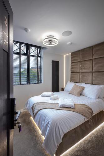 a bedroom with a large bed with white sheets at The Charleston in Blackpool