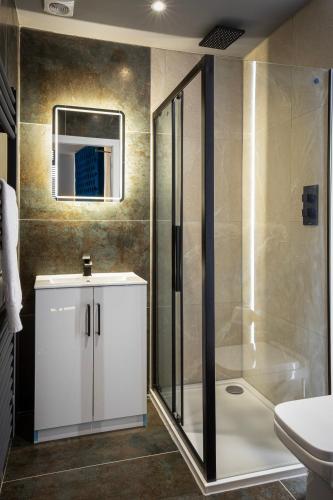 a bathroom with a shower and a sink and a toilet at The Charleston in Blackpool