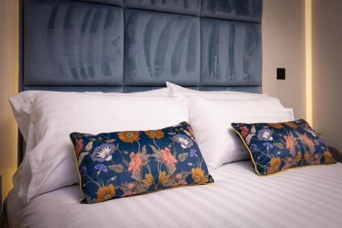 a bed with two pillows and a blue headboard at The Charleston in Blackpool