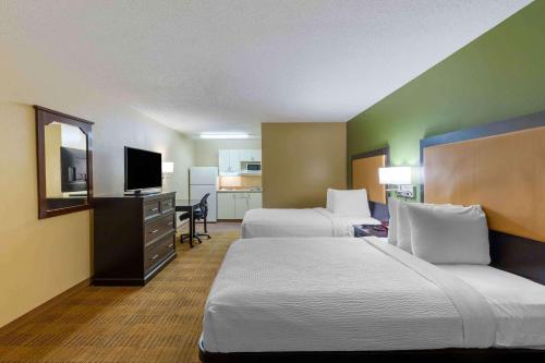 una camera d'albergo con due letti e una televisione di Extended Stay America Select Suites - Durham - University a Durham
