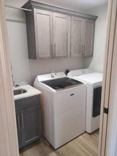 a small kitchen with a washing machine and a sink at Octopus Perfect Location On Pond 3 Mile To Gulf Beach in Bonita Springs