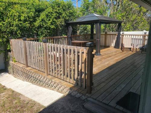 a wooden deck with a gazebo and a table at Octopus Perfect Location On Pond 3 Mile To Gulf Beach in Bonita Springs