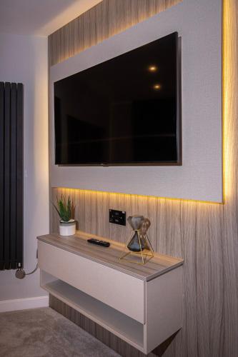 a flat screen tv on a wall with a desk at The Charleston in Blackpool