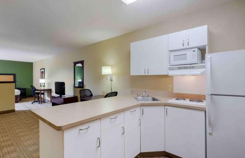 a kitchen with white cabinets and a living room at Extended Stay America Suites - Fairfield - Napa Valley in Fairfield