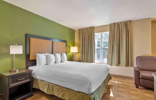 a hotel room with a large bed and a chair at Extended Stay America Suites - Phoenix - Midtown in Phoenix
