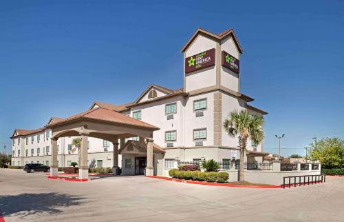 a hotel with a clock tower in a parking lot at Extended Stay America Suites - Baytown in Baytown
