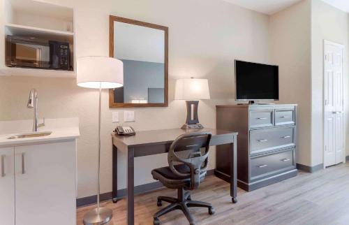 a room with a desk with a chair and a mirror at Extended Stay America Suites - Baytown in Baytown