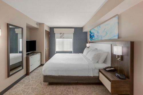 ミシサガにあるExecutive Residency by Best Western Toronto-Mississaugaのベッドルーム(大型ベッド1台、テレビ付)