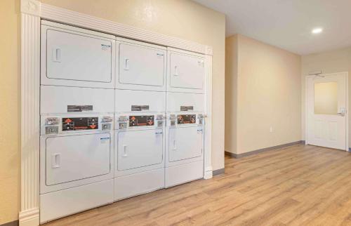 an empty room with four washer and dryer machines at Extended Stay America Suites - Baytown in Baytown