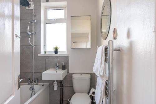 a bathroom with a toilet and a sink and a mirror at Ivy House - 3 Bedroom House - Contractor Stay in Bristol