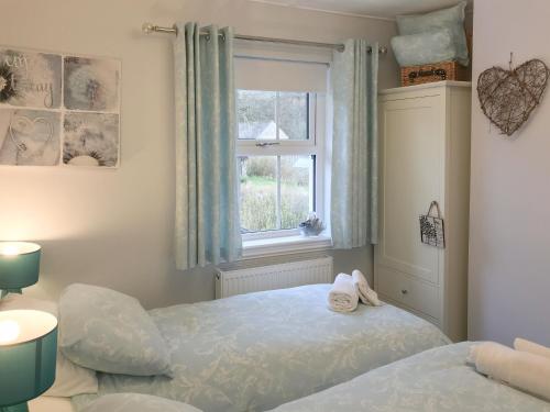 um quarto com uma cama e uma janela em Kielder Kip Cottage em Kielder