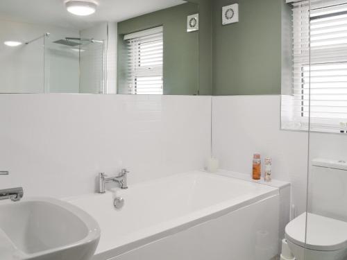 a bathroom with a tub and a sink and a toilet at Middle Cottage in York