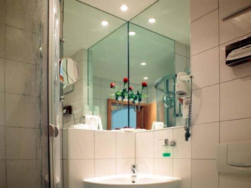 ein Bad mit einem Waschbecken und einem Spiegel in der Unterkunft Altmann's Stube in Erlangen