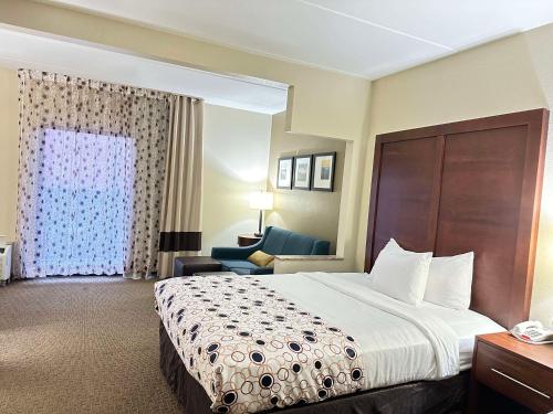a hotel room with a bed and a chair at Vista Suites Pigeon Forge - SureStay Collection by BW in Pigeon Forge