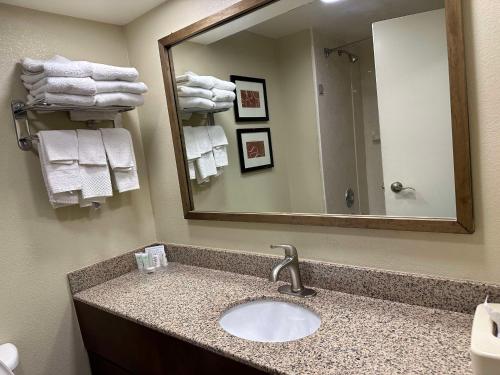 a bathroom with a sink and a mirror and towels at Vista Suites Near Island and Leconte Convention Center in Pigeon Forge