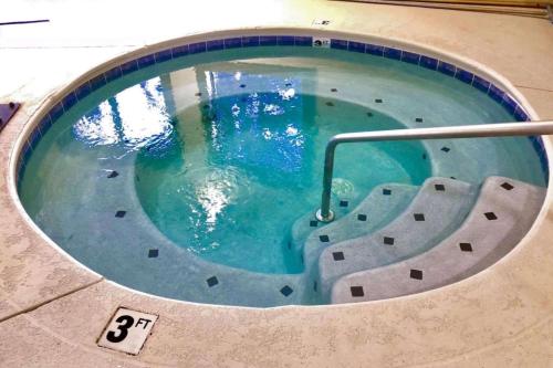 a swimming pool with a slide in the water at Vista Suites Near Island and Leconte Convention Center in Pigeon Forge