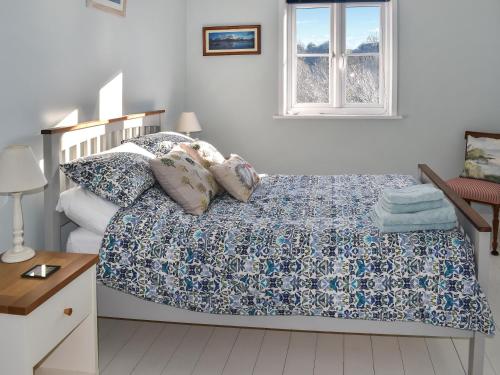 a bedroom with a bed with a blue and white comforter at The Apricot Tree in Carisbrooke
