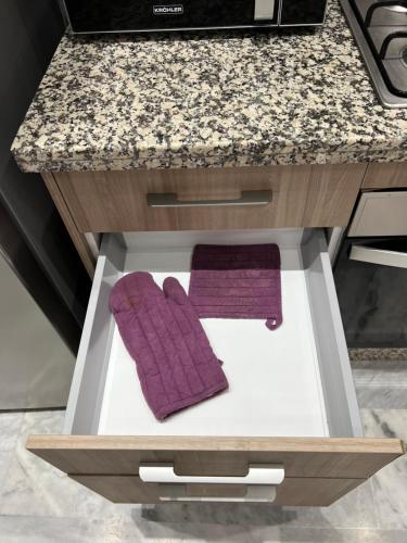 a kitchen with two purple mitts in a drawer at Antonios luxury apartments in Fès