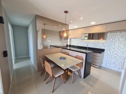 a kitchen with a table and chairs in a kitchen at Apartamento Praia do Futuro mobiliado in Fortaleza
