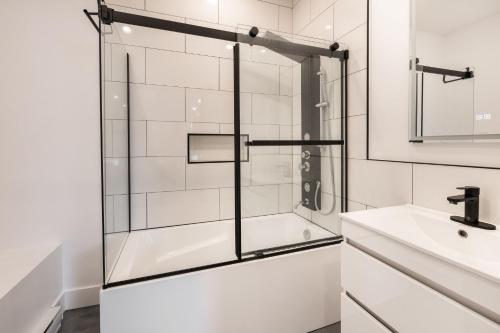 a glass shower door in a bathroom with a sink at 3 Bedrooms apartment-1897 in Montréal