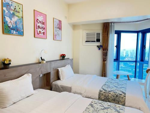 a hotel room with two beds and a window at Dreamy Sunset Bay in Manila