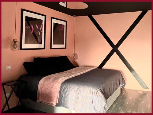 03 LOVE ROOM By Fanny S في سانت كونتان: غرفة نوم بسرير وصورتين على الحائط