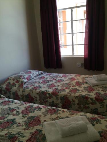 a bedroom with two beds and a window at Casa da Ponte Hotel in Goiás