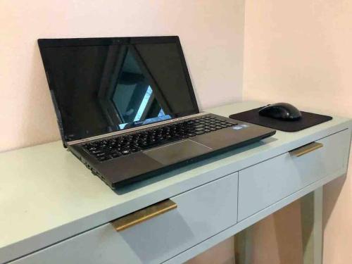 a laptop computer sitting on a desk with a mouse at Beautiful Farmhouse w/ pool on 6 acres ranch in Aubrey